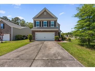 Inviting two-story home with a brick-accented facade, well-maintained landscaping, and a spacious driveway at 9652 Spencer Woods Rd, Ladson, SC 29456