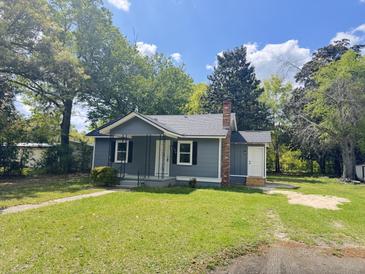Charming single-story home featuring a brick chimney and inviting front porch, surrounded by mature trees at 109 Alexander St, Walterboro, SC 29488