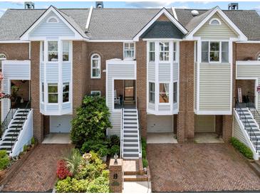 Charming brick townhomes with individual entrances, gardens, and garages enhance curb appeal at 11 Harleston Pl, Charleston, SC 29401