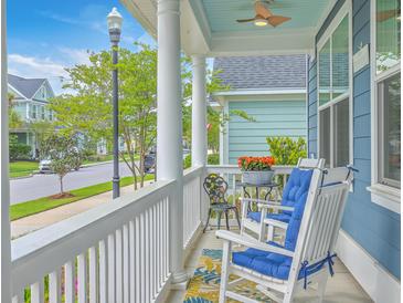 Inviting front porch features rocking chairs with blue cushions and a view of the neighborhood at 110 Angelica Ave, Summerville, SC 29483