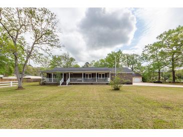Charming brick home features a long, covered front porch and a well-manicured lawn at 110 Wallace Rd, Goose Creek, SC 29445