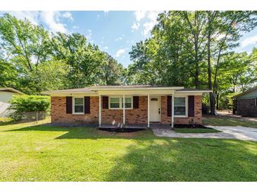 Charming brick home featuring a well-maintained lawn and beautiful landscaping at 115 White Blvd, Summerville, SC 29483