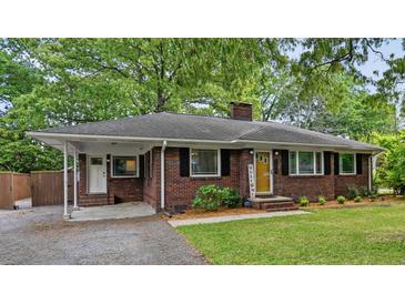 Charming brick home featuring a covered carport, landscaped front yard, and a welcoming yellow front door at 1211 Eastwood Ave, Hanahan, SC 29410