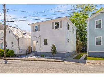 Charming two-story home with white siding, updated windows, and a well-manicured landscape at 13 H St, Charleston, SC 29403