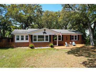 Charming brick home with a cozy front porch and lush trees, perfect for a relaxing coastal lifestyle at 17 24Th Ave, Isle of Palms, SC 29451