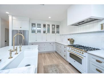 Bright, modern kitchen with marble countertops, stainless steel refrigerator, and hardwood floors at 2013 Grey Marsh Rd, Mount Pleasant, SC 29466