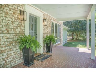 Inviting front porch with brick facade, decorative plants, and a cozy 
