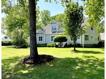 Inviting home with manicured lawn and lush landscaping, offering great curb appeal and a welcoming atmosphere at 5691 Captain Kidd Rd, Hollywood, SC 29449