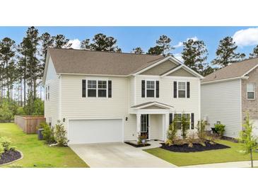 Charming two-story home with landscaped yard, attached garage, and traditional architectural details at 648 Chigwell Springs Ln, Summerville, SC 29486