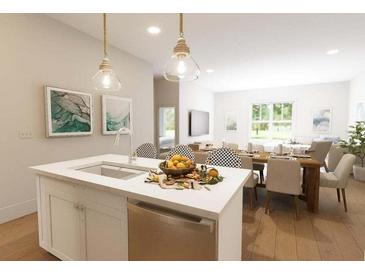 Bright kitchen with an island sink, stainless steel appliances, and pendant lighting at 7621 Indigo Palms Way, Johns Island, SC 29455