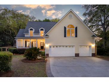 Inviting two-story home with a well-manicured lawn, a cozy front porch, and an attached two-car garage at 79 Rivers Point, Charleston, SC 29412