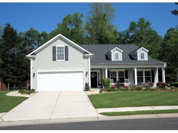 Charming home with a manicured lawn, a two-car garage and a welcoming front porch at 9677 Islesworth Way, Summerville, SC 29485