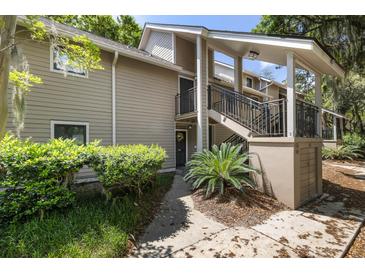 Attractive tan condominium complex with stairs to elevated porch and lush green landscaping at 108 High Hammock Villas Dr, Seabrook Island, SC 29455
