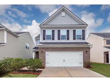 Two-story home featuring a brick and siding facade, attached garage, and manicured lawn at 169 Longford Dr, Summerville, SC 29483