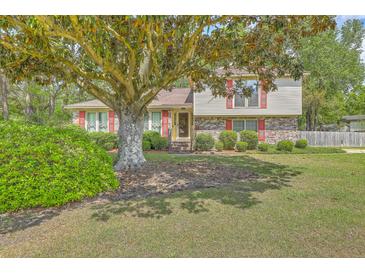 Charming two-story home with brick accents, red shutters, and a spacious landscaped front yard at 2042 Dogwood Rd, Charleston, SC 29414