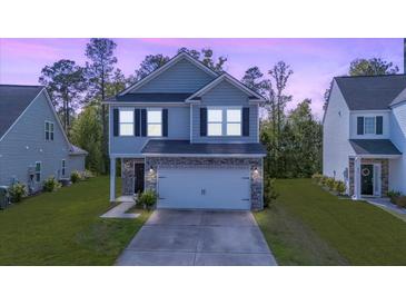 Charming two-story home with stone accents, well-maintained lawn, and an attached two-car garage at 234 Daniels Creek Cir, Goose Creek, SC 29445
