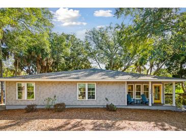 Charming coastal home featuring a shake shingle exterior, inviting front porch, and lovely mature landscaping at 248 Forest Trail, Isle of Palms, SC 29451