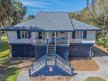 Charming coastal home with elevated design, staircase entry, and quaint front porch at 3308 Myrtle St, Edisto Beach, SC 29438