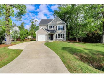 Charming two-story home with a well-manicured lawn and a long driveway leading to the attached garage at 3374 Dunwick Dr, Johns Island, SC 29455