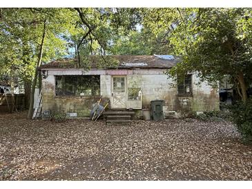Exterior shot of a home in disrepair with missing roof shingles and a leaf-covered yard at 5901 Sedgefield Dr, Hanahan, SC 29410