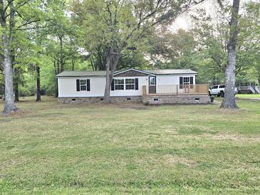 Charming home featuring a spacious front yard, a wooden deck, and a metal roof at 620 Coral Acres Dr, Moncks Corner, SC 29461