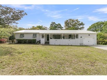 Charming single story home with white painted brick and a screened in porch at 939 Mikell Dr, Charleston, SC 29412