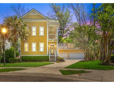 Charming yellow two-story home with a detached two car garage and mature trees at 1002 Blockade Runner Ct, Charleston, SC 29414