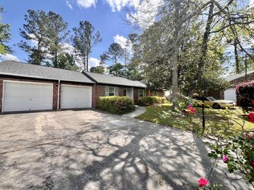 Charming brick home with two-car garage, mature landscaping, and a long driveway at 1009 Highland Pines Rd, Ladson, SC 29456