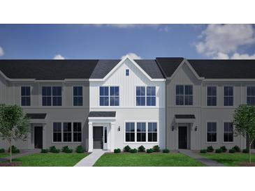 Charming townhome with bright, white siding, a gray roof, and manicured front lawn at 121 Brown Swiss Cir, Summerville, SC 29483