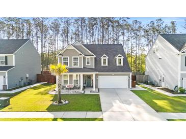 Charming two-story home with grey siding, a manicured lawn, and a welcoming front porch at 149 Caleb Ct, Ladson, SC 29456