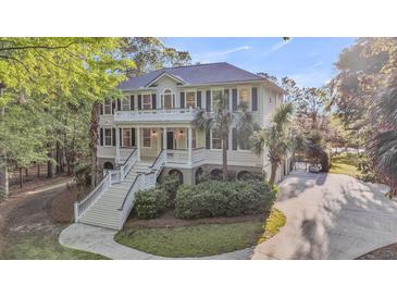Stately two-story home with double porches and meticulous landscaping boasts a luxurious appeal at 2037 Shell Ring Cir, Mount Pleasant, SC 29466