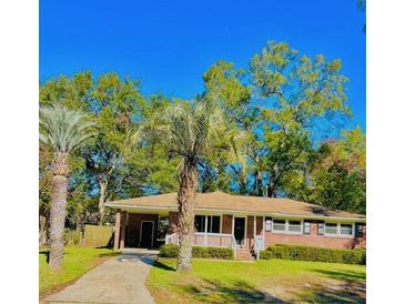 Charming single-story brick home featuring a well-maintained lawn and mature palm trees at 26 Elmora Ave, Goose Creek, SC 29445