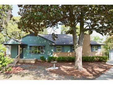 Charming home with a brick and siding exterior and a mature tree in the front yard at 5452 E Lakeland Dr, North Charleston, SC 29406