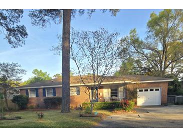 Charming single-story brick home featuring a well-manicured lawn and attached garage at 5937 Willard Dr, Hanahan, SC 29410