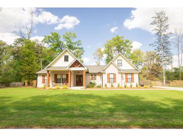 Charming single-story home with a beautifully landscaped front yard and inviting front porch with craftsman style columns at 74 Longleaf Dr, Walterboro, SC 29488