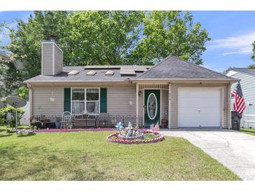 Charming single-story home featuring a well-manicured lawn and an inviting green front door at 8219 Quail Hollow Ct, North Charleston, SC 29420