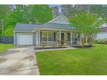 Charming single-story home with a well-manicured lawn, flowering bushes and an attached garage at 9156 Fieldstone Trce, Summerville, SC 29485