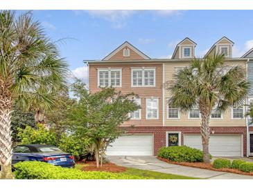 Charming townhome exterior with well-manicured landscaping, garage, and palm trees at 9316 Sweetbay Ct, Ladson, SC 29456