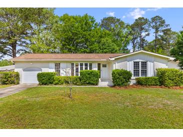 Charming brick home with attached garage and lush landscaping on a sunny day at 111 Driver Ave, Summerville, SC 29483