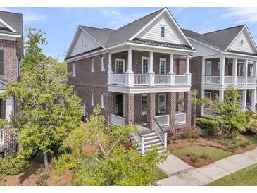 Charming two-story brick home with double front porches, white railings, and manicured landscaping at 112 Brailsford St, Charleston, SC 29492