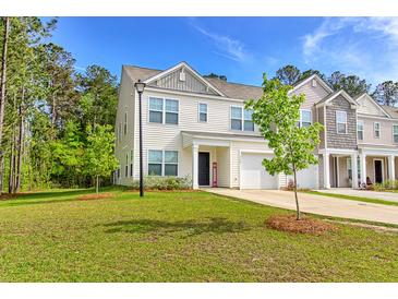 Charming two-story home with attached garage, well-manicured lawn, and inviting curb appeal at 115 E East Sunrise Lane, Summerville, SC 29486