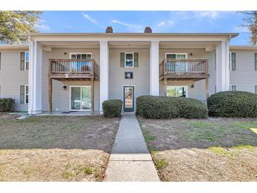 Inviting condominium featuring private balconies, lush landscaping, and a well-maintained facade at 1402 Camp Rd # 8B, Charleston, SC 29412