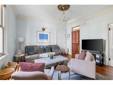 Bright living room featuring stylish furnishings, hardwood floors, and elegant lighting fixture at 162 Spring St # A, Charleston, SC 29403