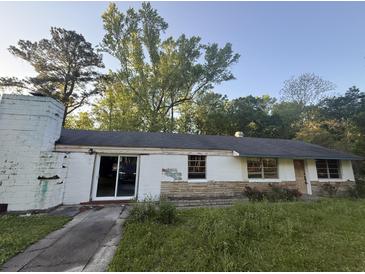 Modest ranch-style home with a partially overgrown yard and cinderblock construction at 1633 Southwick Dr, Johns Island, SC 29455