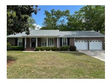 Charming brick home featuring a well-manicured front yard with lush landscaping and a two-car garage at 206 Brailsford Rd, Summerville, SC 29485