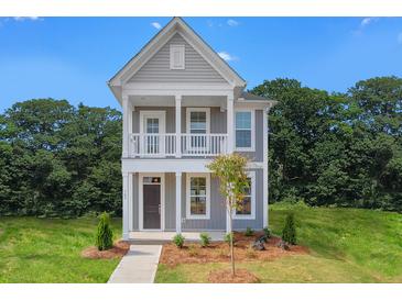 Charming two-story home featuring a covered porch, balcony, and well-maintained landscaping at 308 O'Malley Dr, Summerville, SC 29483