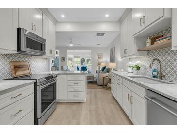 Bright kitchen featuring white cabinets, stainless steel appliances, and stylish backsplash tile at 3372 Billings St, Mount Pleasant, SC 29466
