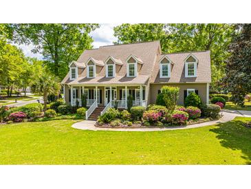 Charming home featuring a welcoming front porch and meticulously landscaped front yard at 4403 Wild Thicket Ln, North Charleston, SC 29420