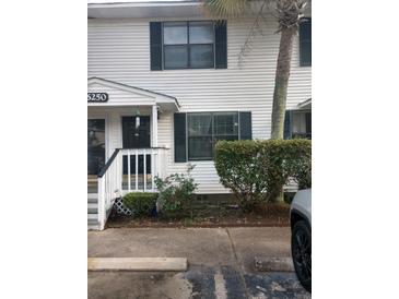 Charming two-story townhouse with white siding, black shutters, and a cozy front porch at 6250 Brandt St # 51-D, North Charleston, SC 29406