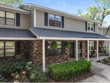 Charming townhome featuring a brick facade, covered porch, manicured landscaping and classic shutters at 880 Simpkins St # 2, Charleston, SC 29412